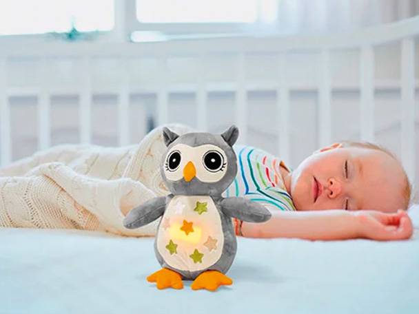 Plüsch-Eule und schlafendes Baby.