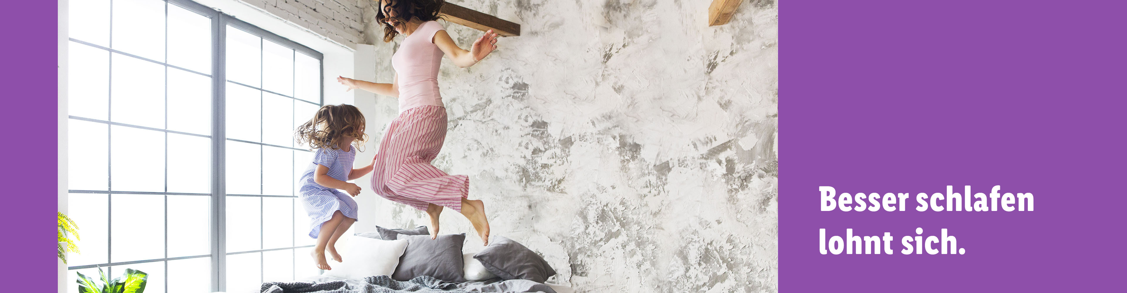 Mutter und Tochter springen auf dem Bett.