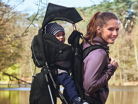 Kind in Tragehilfe im Freien.