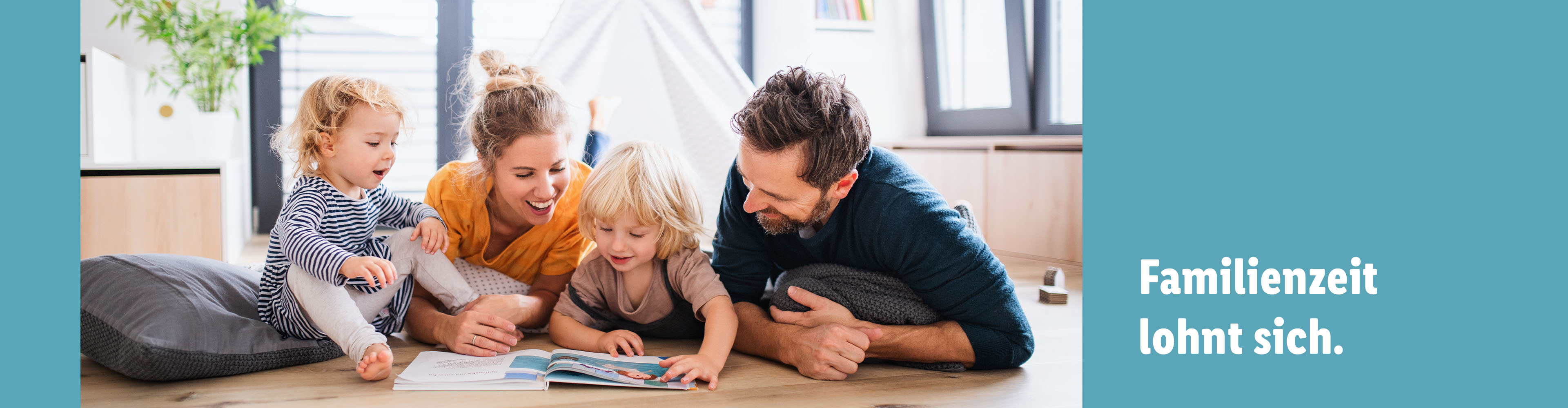Familie liest gemeinsam ein Buch auf dem Boden.