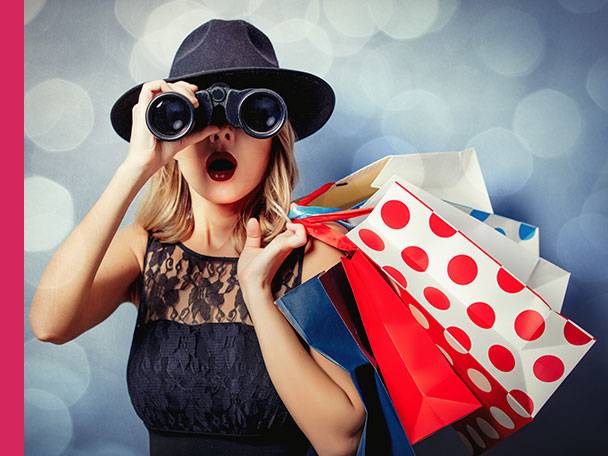 Frau sucht mit Fernglas Einkaufstüten.