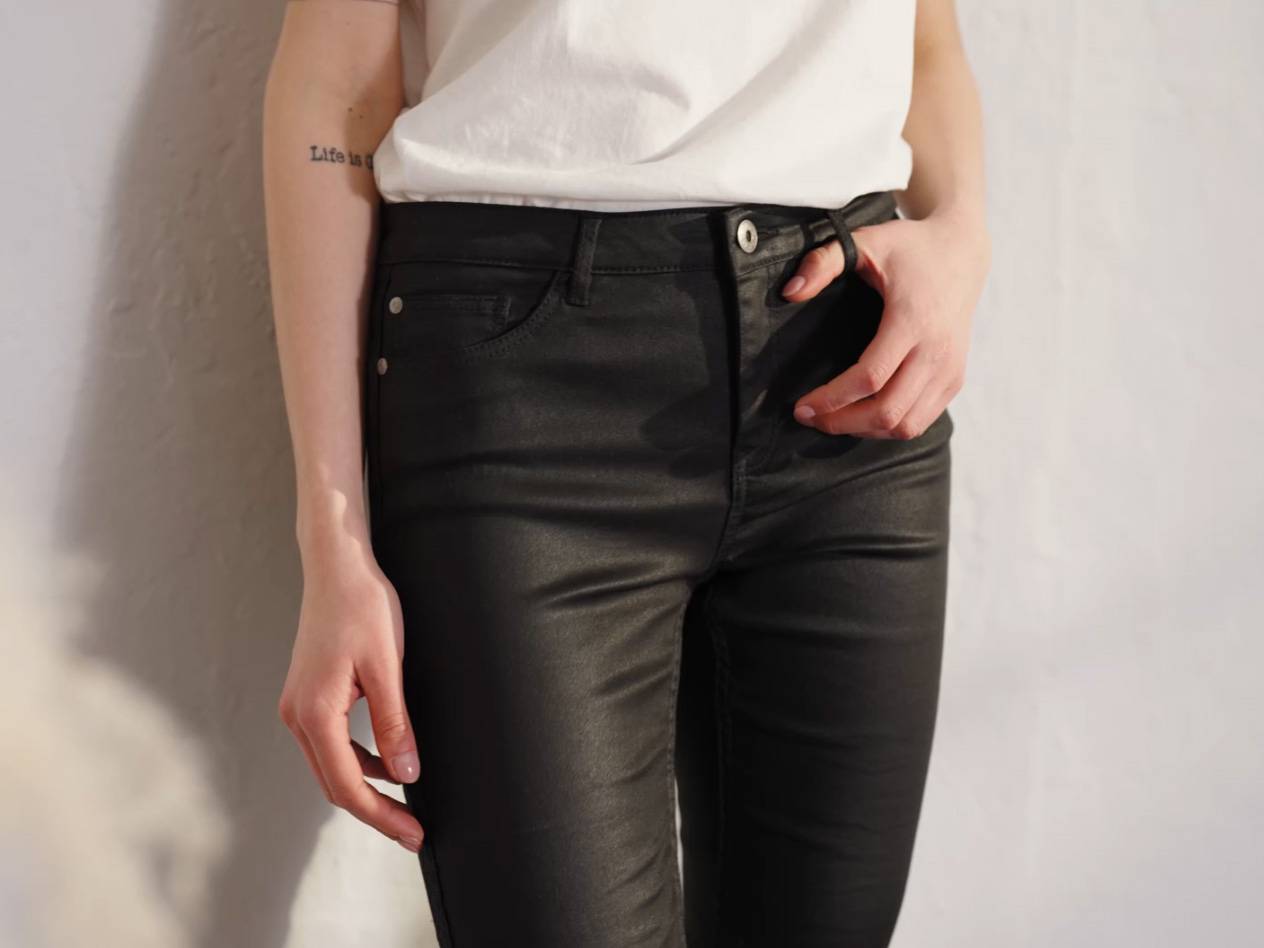 Schwarze Lederhose und weißes T-Shirt.