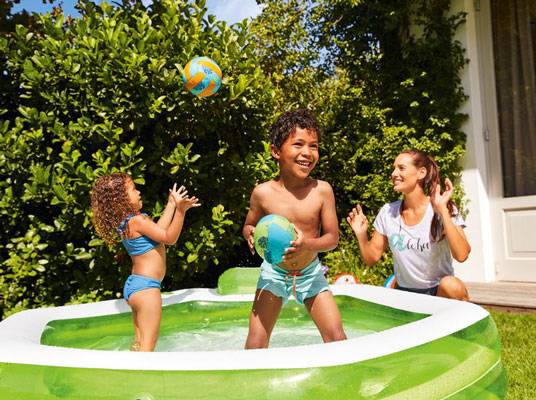 Kinder spielen mit Bällen im Pool.
