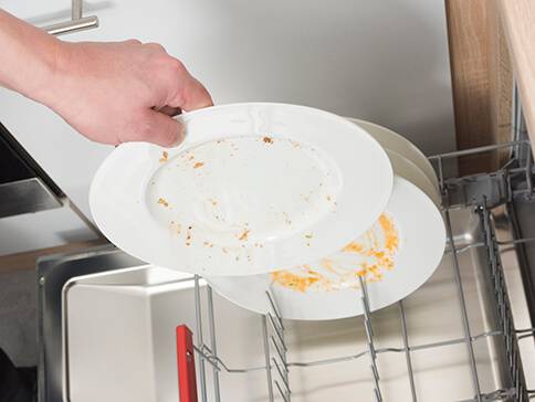 Schmutzige Teller werden in den Geschirrspüler gestellt.