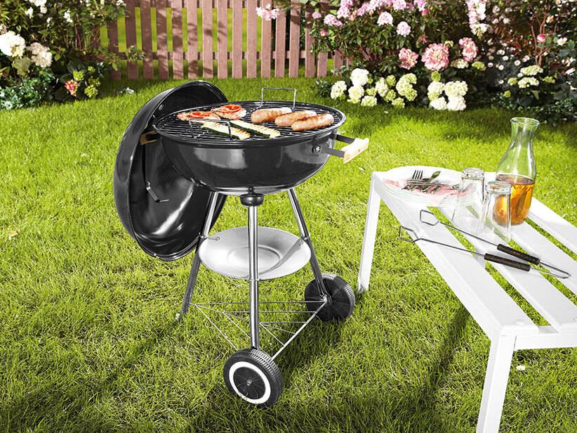 Holzkohlegrill und Grillzubehör im Garten.