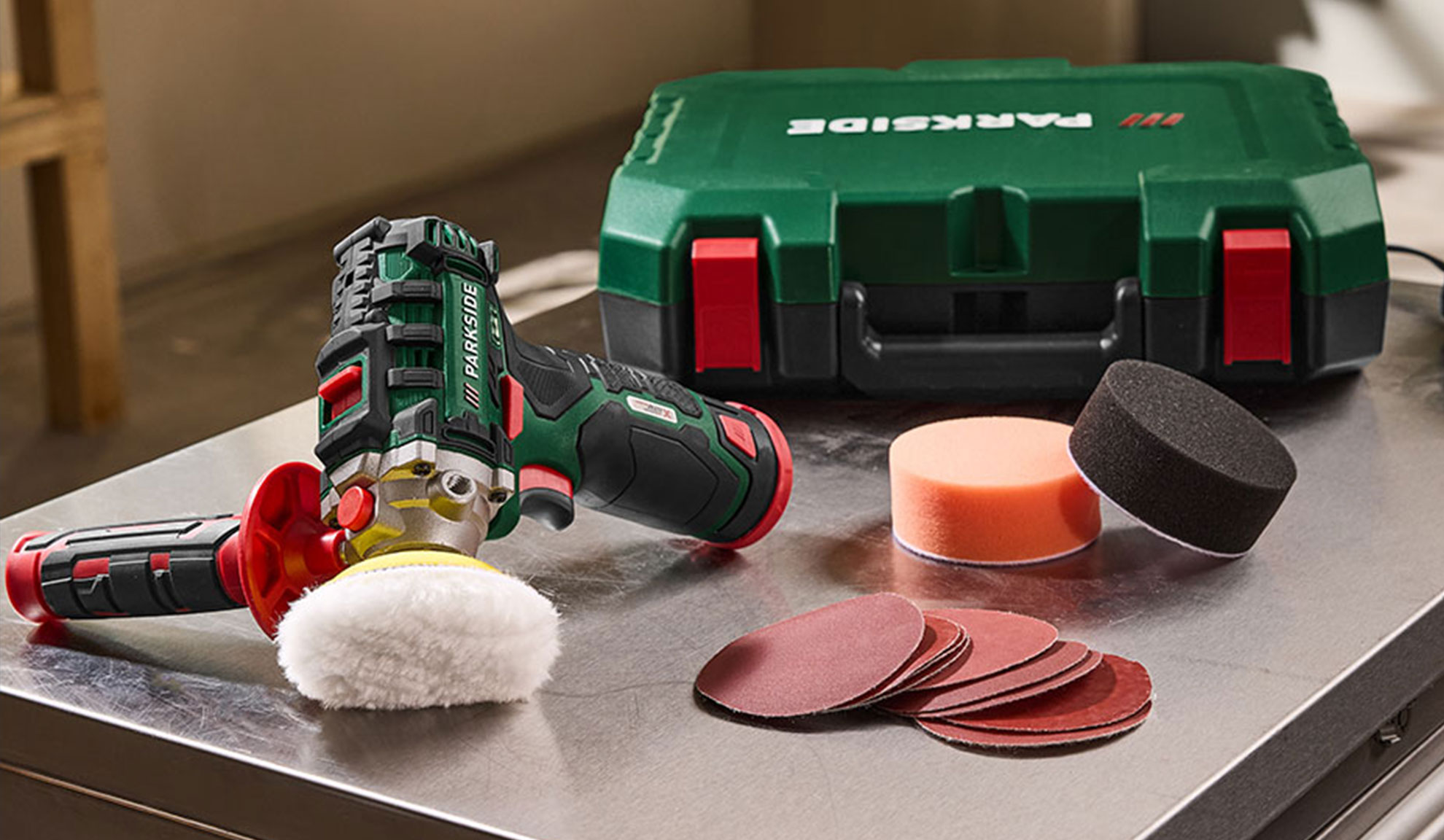 Akku-Poliermaschine mit Zubehör, inklusive Polierpads und Schleifscheiben.