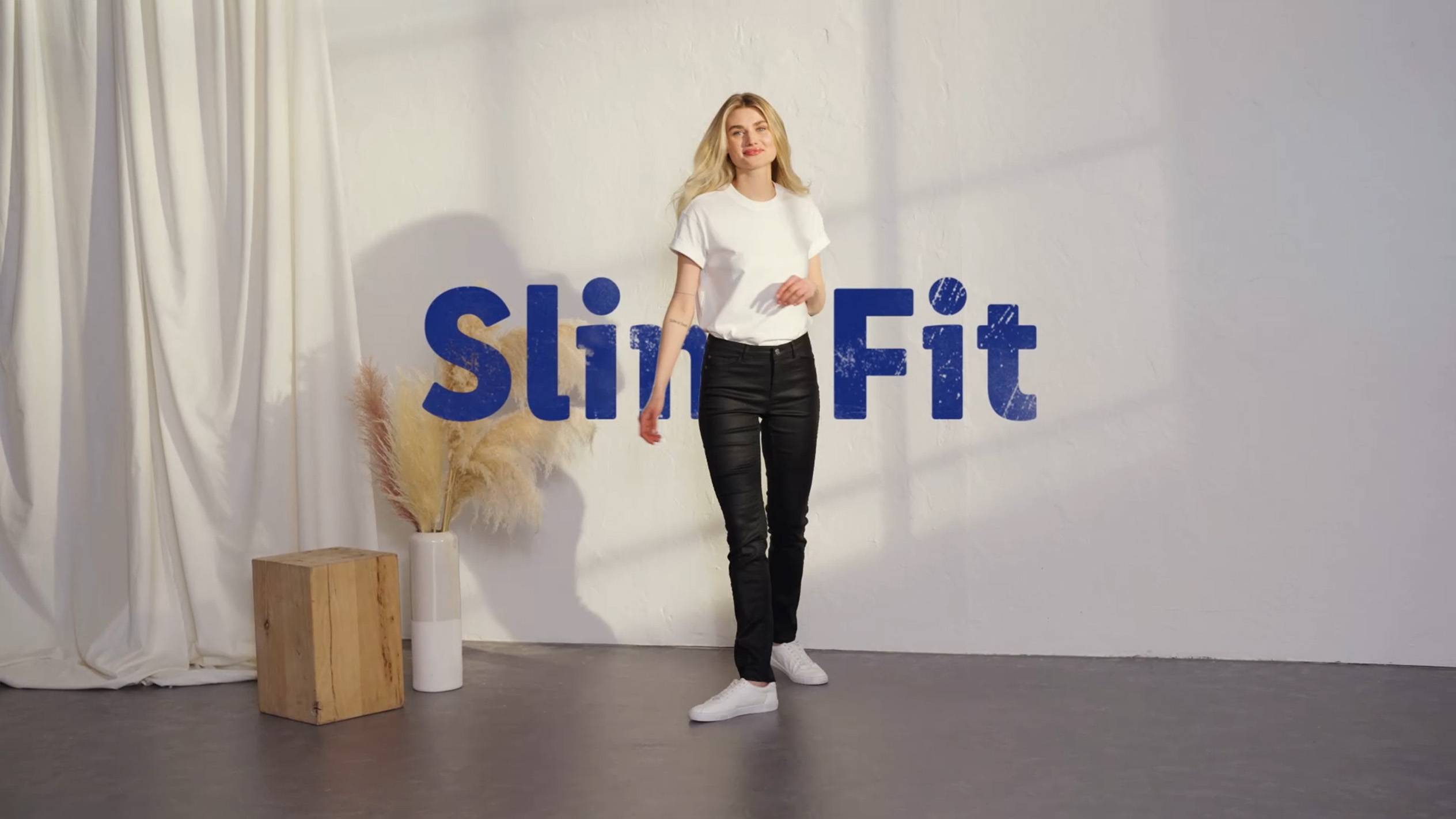 Frau in Slim Fit Jeans und weißem T-Shirt.