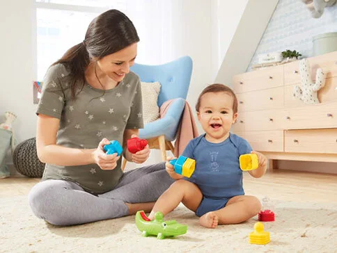 Mutter und Baby spielen mit bunten Spielzeug.