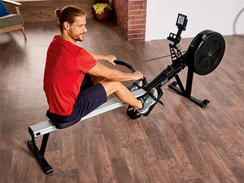 Mann benutzt Rudergerät.