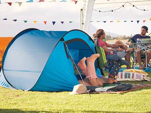 Pop-up Zelt und Campingstühle auf einem Festival.