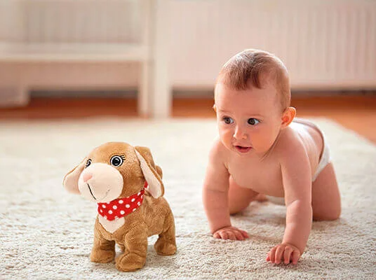 Ein Baby spielt mit einem süßen, laufenden Plüschtier.