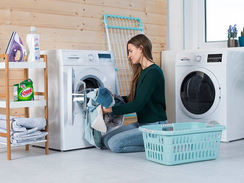 Bosch Waschmaschine, Trockner, Wäschekorb und Formil Waschmittel.