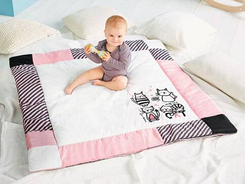 Babydecke und Spielzeug mit Katzenmotiv.