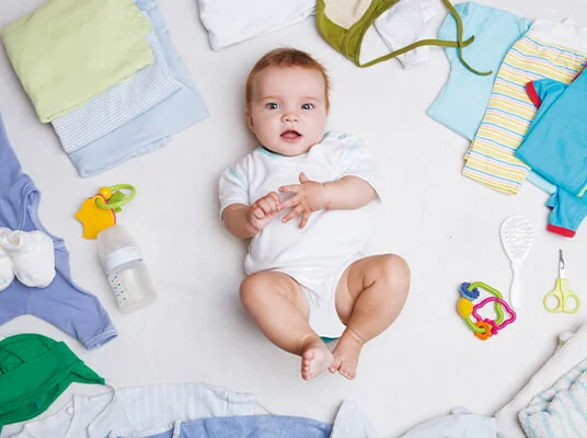 Babykleidung, Babyflasche und Baby.