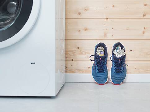 Waschmaschine und Sportschuhe mit Papier gefüllt.