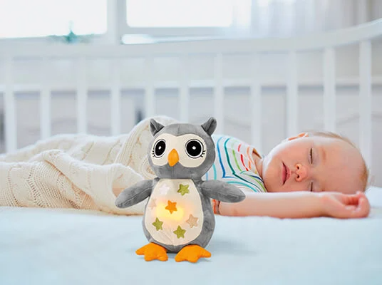 Plüsch-Eule und schlafendes Baby.
