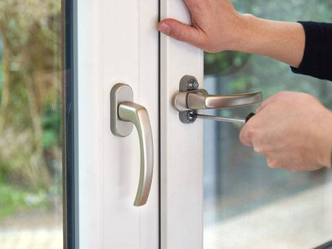 Fenstergriff und -schloss werden montiert.