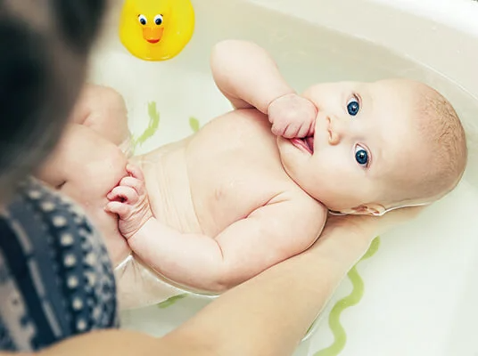 Baby im Bad mit Gummiente.