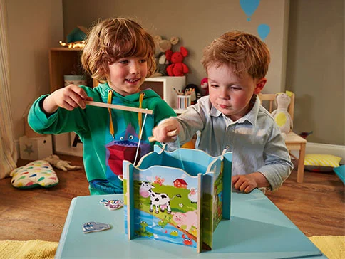 Kinder spielen ein Bauernhof-Angelspiel.