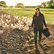 Bauernfrau mit Hühnern auf einem Bauernhof.