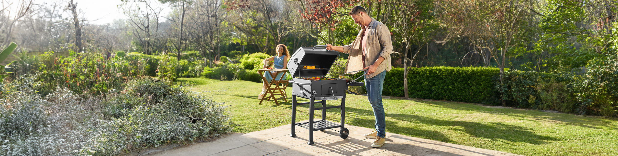 Mann grillt im Garten.