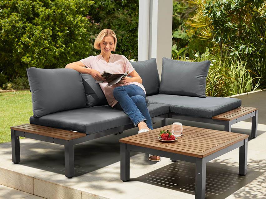 Gartenmöbel-Set: Eckcouch und Couchtisch aus Holz und Metall.