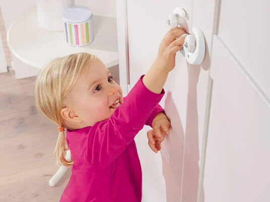Kind benutzt Türsicherungen.