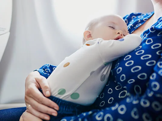 Baby schläft in Mamas Armen.
