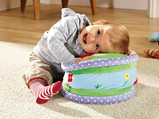 Baby spielt mit weichem Trommel-Spielzeug.