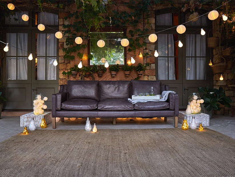 Ledercouch, Außenbeleuchtung und dekorative Lichter auf der Terrasse.