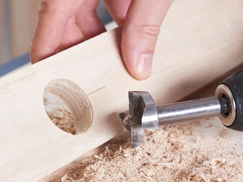 Holz wird gebohrt, Loch entsteht.