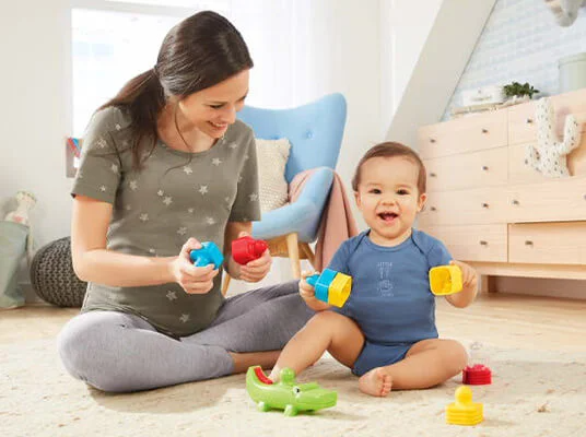 Mutter und Kind spielen mit Fisher-Price Spielzeug.