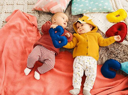 Babykleidung und weiche Buchstabenspielzeug.