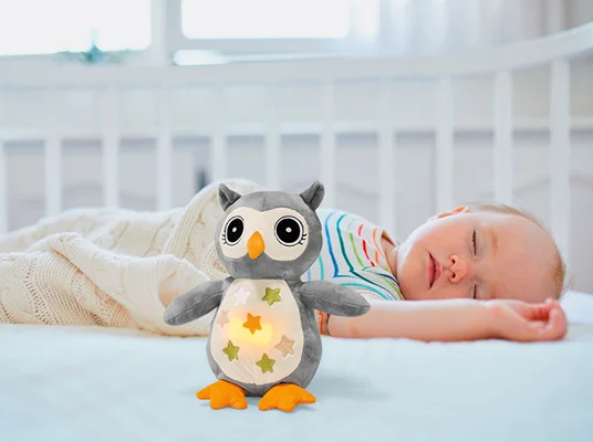 Schlafendes Baby mit Plüsch-Eule.