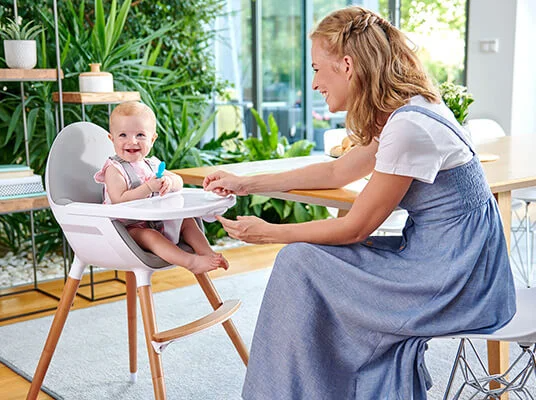 Baby in Hochstuhl, Holzbeine.