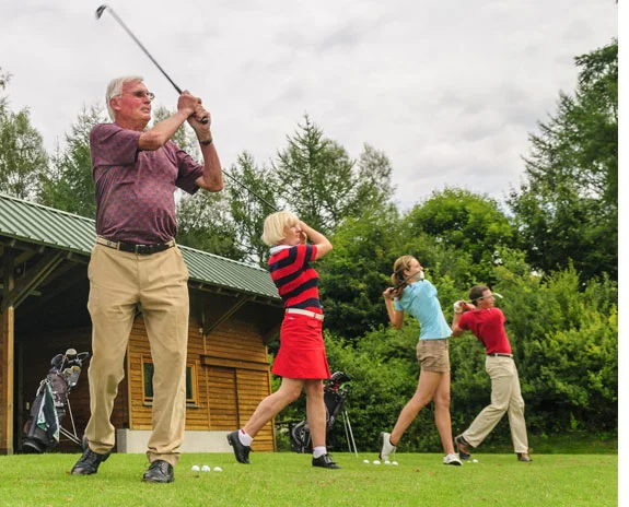 Golfspieler; ein älterer Mann und drei jüngere Frauen.