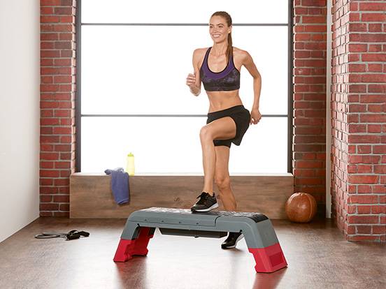 Frau in Sportkleidung und Fitness-Step.