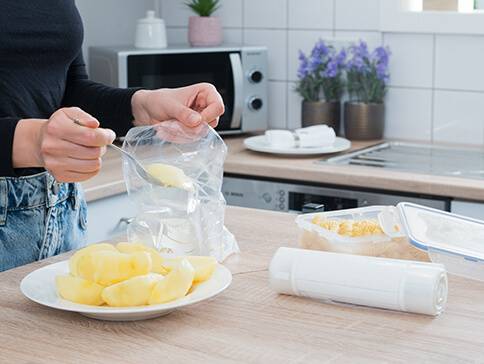 Kartoffeln in Vakuumbeutel und Plastikboxen verpacken.
