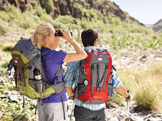 Wanderrucksäcke und Fernglas in der Natur.