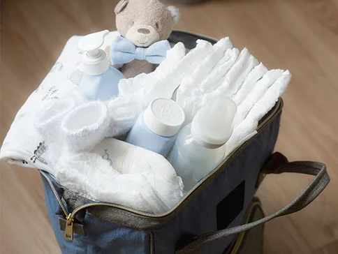 Windeln, Babykleidung und Pflegeprodukte in der Tasche.