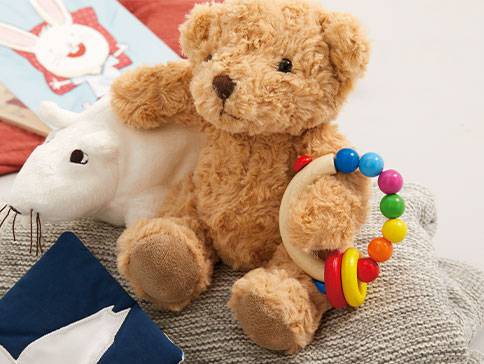 Teddybär, Maus und bunter Beißring als Babyspielzeug.