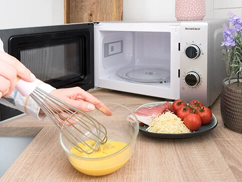 SilverCrest Mikrowelle, Eier, Schneebesen und Zutaten.