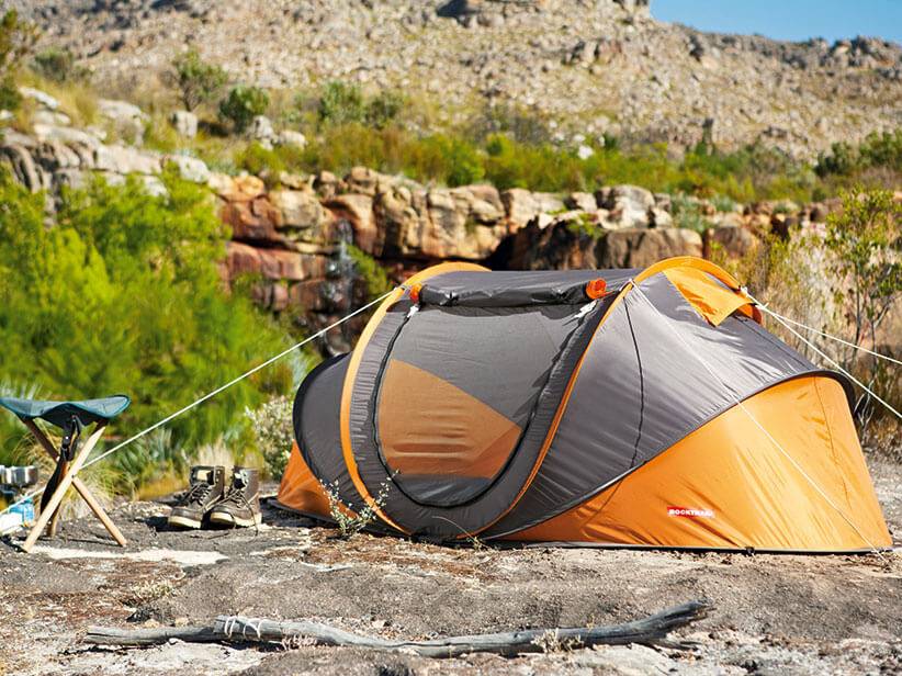 Pop-up-Zelt und Campinghocker in der Natur.
