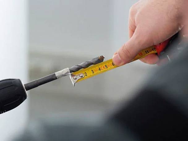 Bohrer und Maßband im Einsatz.