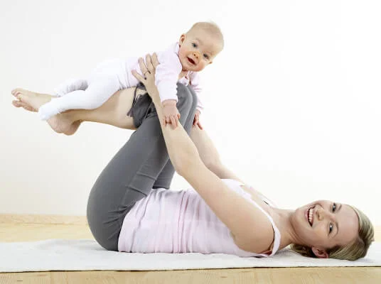 Mutter macht Übungen mit Baby.