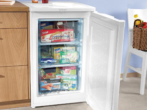 Weißer Gefrierschrank mit gefrorenem Essen und Schubladen.