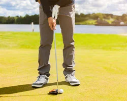 Golfer puttet auf dem Grün.