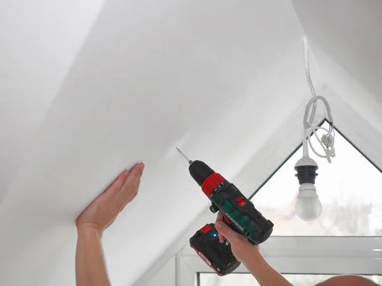 Montage einer Deckenleuchte mit einem Bosch-Bohrschrauber.