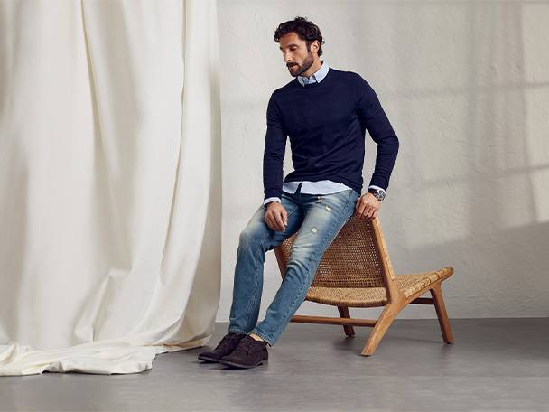 Herrenpullover und Jeans in lässigem Stil.