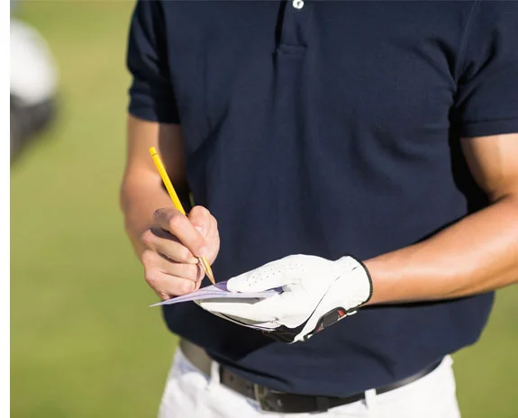 Golfer notiert mit Bleistift und Handschuh Ergebnisse.